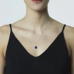 Colgante de oro blanco con zafiro oval y orla de diamantes