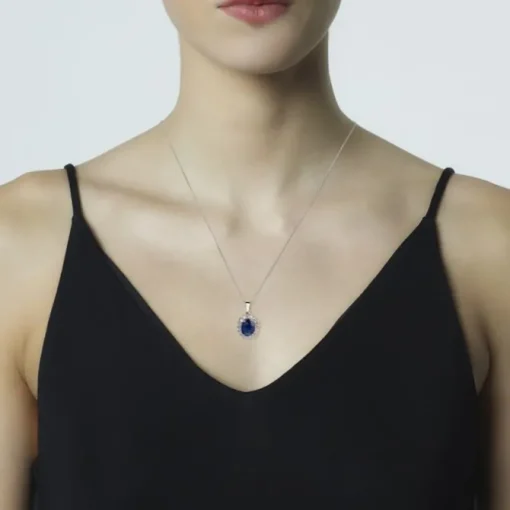Colgante de oro blanco con zafiro oval y orla de diamantes