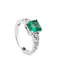 Sortija de oro blanco con esmeralda en 4 garras y diamantes laterales