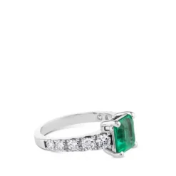 Sortija de oro blanco con esmeralda en 4 garras y diamantes laterales